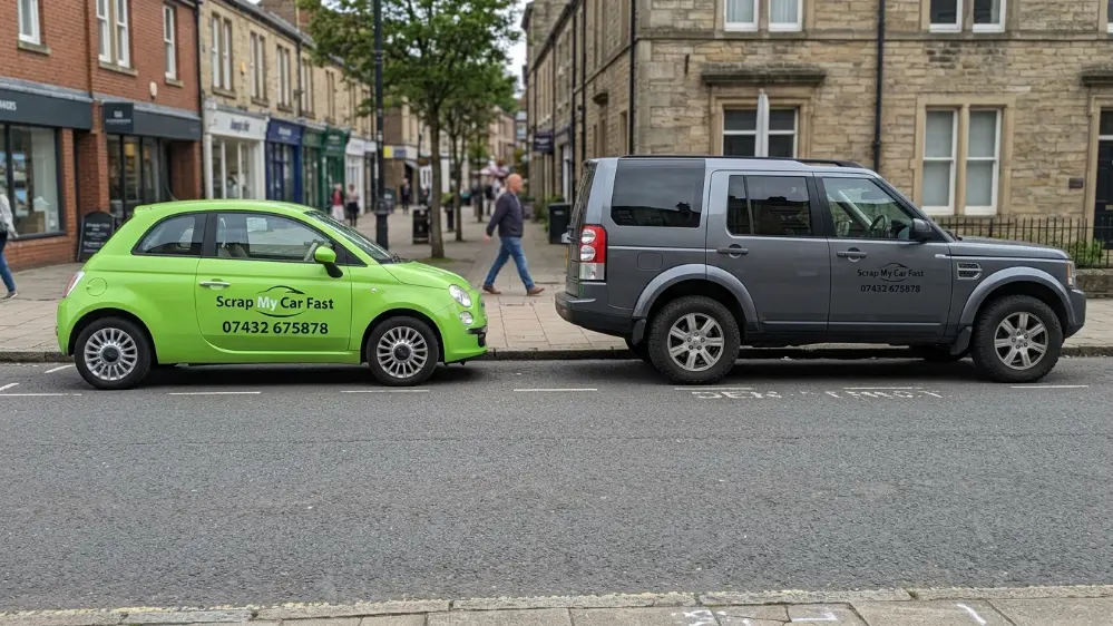 Small city car next to large SUV showing difference in vehicle size and scrap value